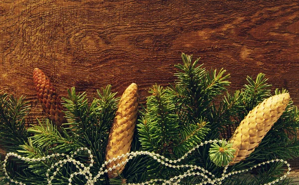 Christmas decoration, holidays, new year and decor concept. Close up of natural fir branch and fir cone on wooden textural table — Stock Photo, Image