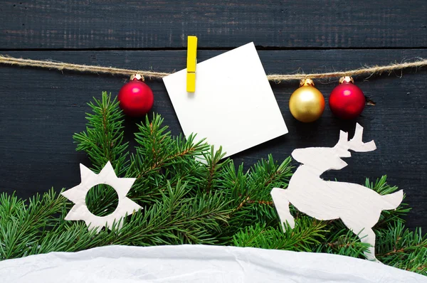 Tarjeta de Navidad con adornos de árboles de Navidad y una rama de abeto en un hilo . —  Fotos de Stock