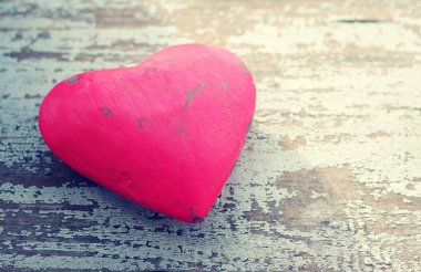 Red heart on a grunge wooden old background.