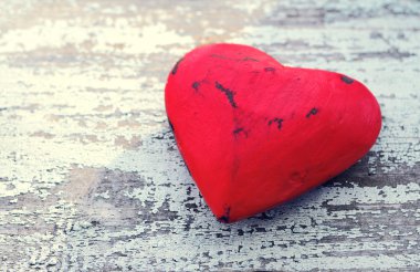 Red heart on a grunge wooden old background.
