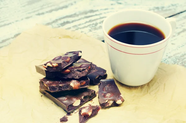 Chocolate negro con nueces y una taza de café negro —  Fotos de Stock