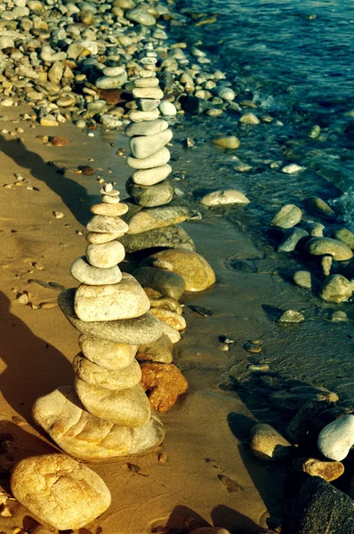 Pyramid from sea stones against the sea. — Stock Photo, Image