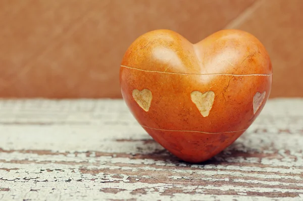 Coeur avec des pierres sur un vieux fond en bois . — Photo