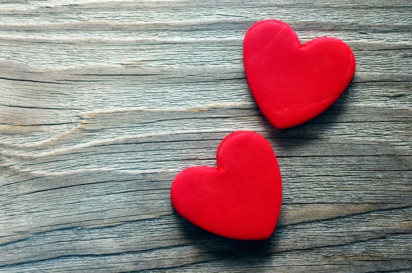 Dois corações vermelhos em um fundo velho de madeira. Cartão romântico . — Fotografia de Stock
