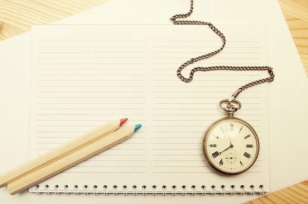 Two colored pink and blue wooden pencils, notebook and old pocket watch — Stock Photo, Image