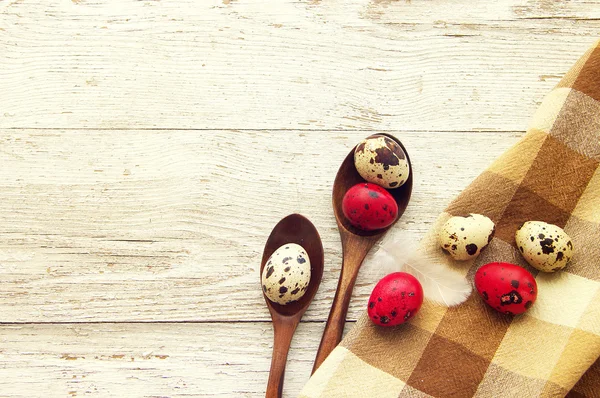 Quail colorful Easter eggs in wooden spoons. — Stock Photo, Image