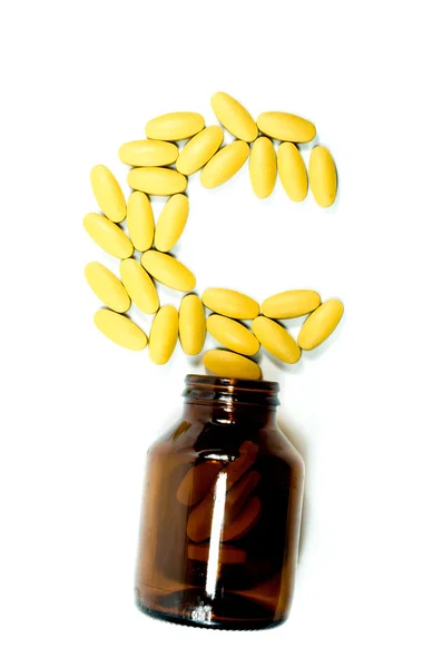 Vitamin-C-Tabletten fließen aus einem Behälter lizenzfreie Stockfotos