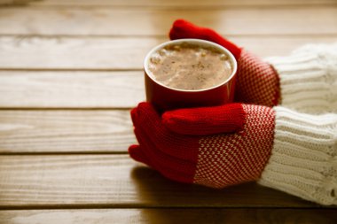 Elinde kahve fincan sıcak tutan eldiven