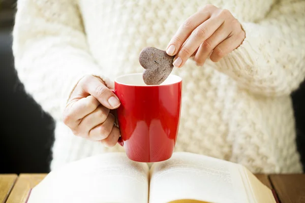 Donna mano immersione cookie nel tè — Foto Stock