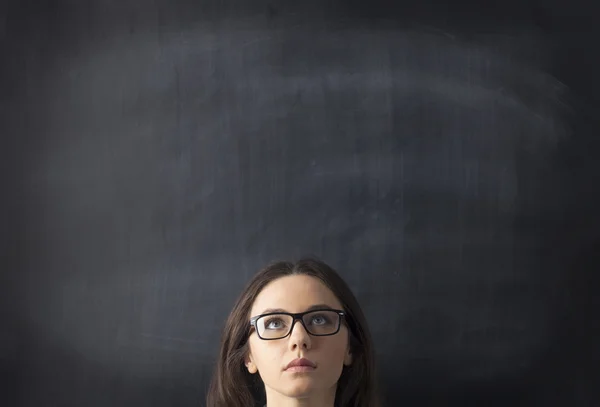 Ung kvinna tittar upp med blackboard — Stockfoto