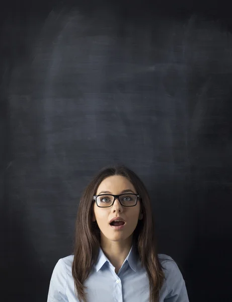 Ung kvinna tittar upp med blackboard — Stockfoto