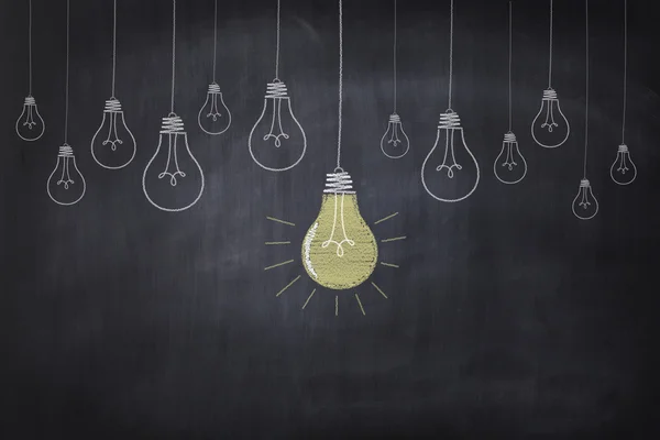 The chalkboard drawing shows light bulbs — Stock Photo, Image