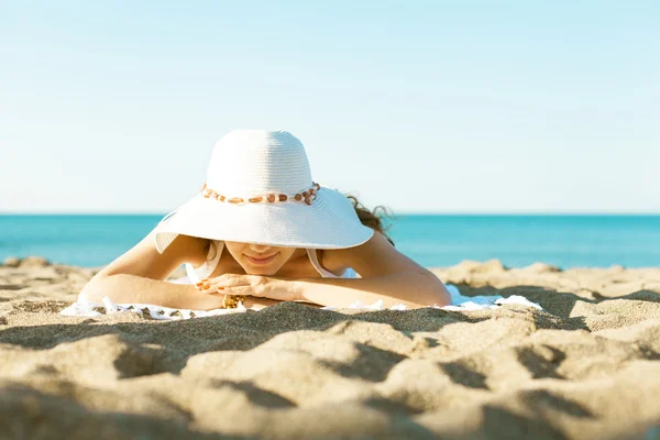 Giovane donna sdraiata sulla spiaggia di sabbia — Foto Stock