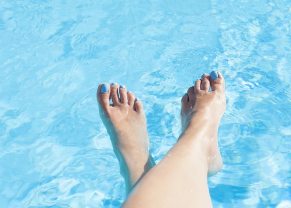 Pies de una mujer en la piscina — Foto de Stock