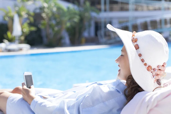 Havuz kenarında cep telefonu kullanan kadın — Stok fotoğraf