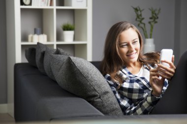 Akıllı telefonunu kullanan güzel genç bir kadın.