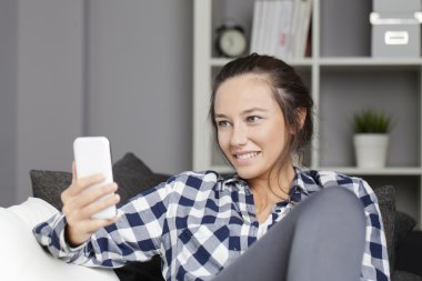 Genç kadın kanepe ile smartphone 