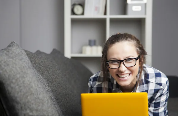 Grappige jonge vrouw lachen in woonkamer — Stockfoto