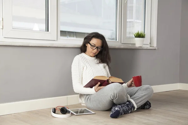 Giovane donna che legge un libro a casa — Foto Stock