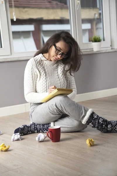 Donna pensierosa scrivere una cosa a casa — Foto Stock