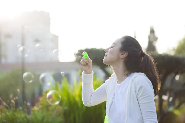 Jonge vrouw blazen bubbels — Stockfoto