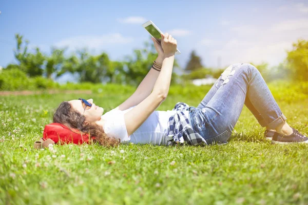 Jonge vrouw met tablet in de zomer — Stockfoto