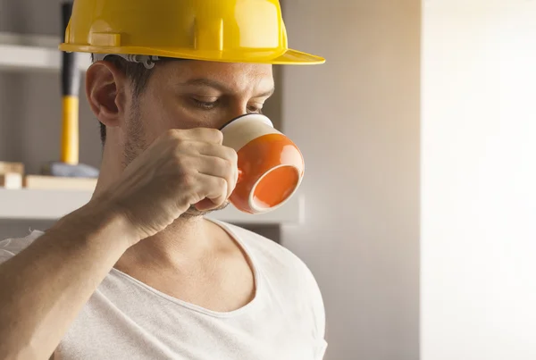 Trabalhador no capacete tendo coffee break — Fotografia de Stock