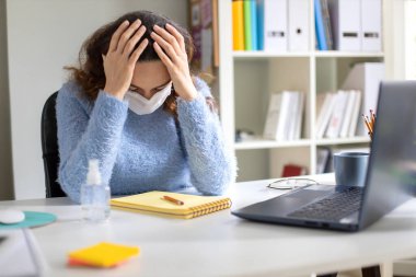 Coronavirüs salgınından sonra evde çalışan genç bir kadın.