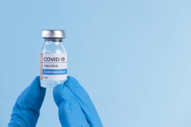 Koruyucu eldivendeki doktor Coronavirus Covid-19 aşı şişesini tutuyor. Coronavirus 2019-nCoV konsepti