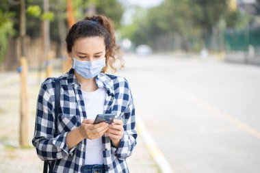 Coronavirus 'u önlemek için yüz koruyucu maske takan genç bir kadın.