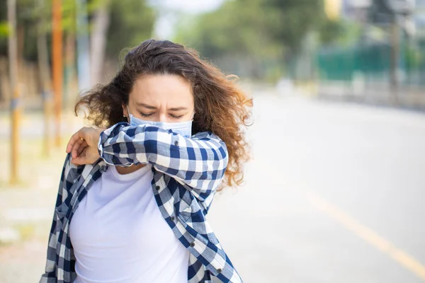 Mujer Con Mascarilla Estornudando Codo Mientras Camina Por Calle — Foto de Stock