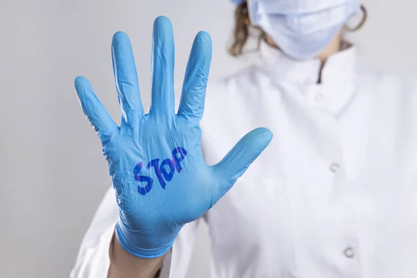 Stop the coronavirus. Stop written on the doctor\'s hand with surgical glove. Concept of coronavirus quarantine. Prevent the spread of infectious diseases