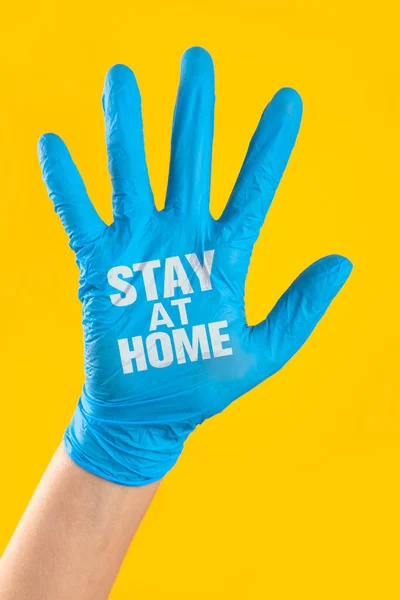 Stay home written on the doctor\'s hand with surgical glove. Prevent the spread of infectious diseases