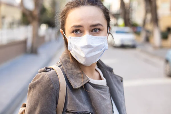 Young woman with face mask on the street.  Coronavirus self-protection concept