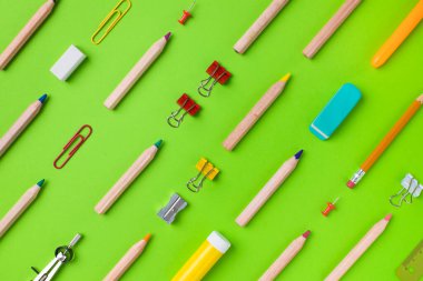 Yeşil arka planda okul eşyaları. Okul konseptine dönelim..
