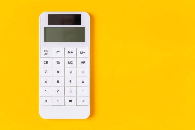 Sarı arkaplanda kopyalama alanı olan beyaz hesap makinesi 