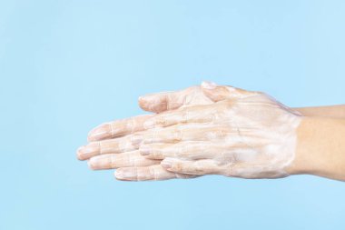 Kadın ellerini sabunla yıkıyor. Yıkanan kadın elleri izole edilmiş.