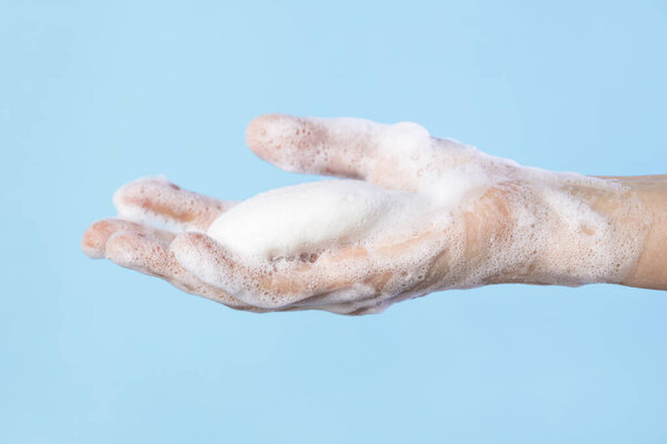 Woman washing hands with soap. Closeup of female washing hands isolated