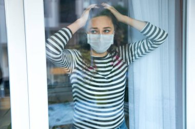 Young woman who cannot leave the house in quarantine due to an epidemic Covid-19 clipart