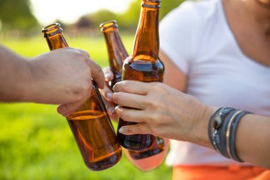 Birayla şişeleri tutan ve tezahürat yapan eller