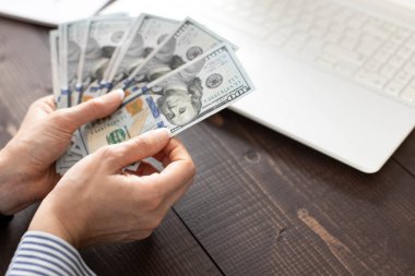 Ofis masasında Amerikan Doları 'nı sayan tanınmamış genç bir kadın.