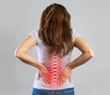 Young woman suffering from lower back pain. Young woman injured suffering from backache, Spine in 3d clipart