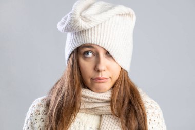 Kışın kendini kötü hisseden genç bir kadın. Hüzünlü yüz ifadesi, stüdyo fotoğrafı.