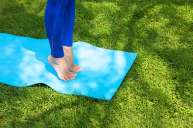 Yeşil çimenlerin üzerinde Yoga egzersiz yaparak genç kadın