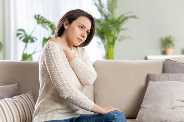 Young Woman Sitting Home Her Sofa Touching Back Her Neck — Stock Photo, Image