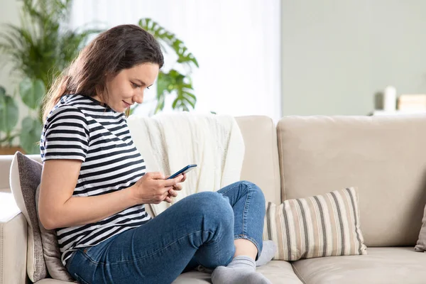 Young Woman Using Mobile Phone While Sitting Sofa Home — Stock Photo, Image