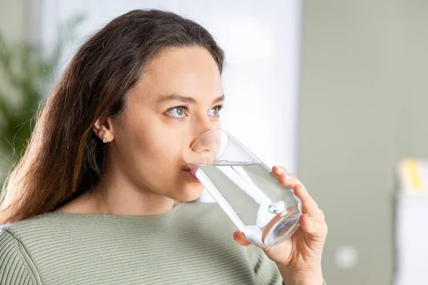 Mujer Joven Bebiendo Agua Sentada Sofá Casa Beneficios Para Salud —  Fotos de Stock