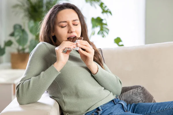 Femme Heureuse Mangeant Chocolat Assise Sur Canapé Dans Salon Maison — Photo