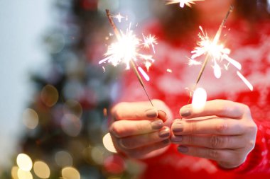 Noel ağacında yanan maytap tutan kadın. Yeni yıl kutlaması 