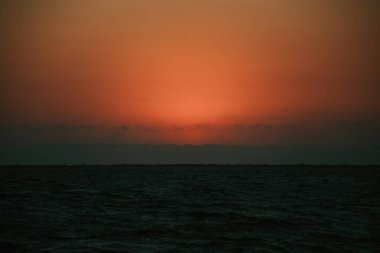 Pasifik Okyanusu üzerinde bulutlu kırmızı gün batımı